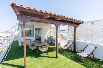 a patio with a table and chairs on a balcony at Glyfada Residence Top Floor With Sea & Tower View in Athens