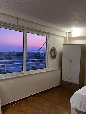 a bedroom with a large window with a view of a bridge at Glyfada Residence Top Floor With Sea & Tower View in Athens