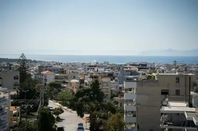 a city with buildings and the ocean in the background at Glyfada Residence Top Floor With Sea & Tower View in Athens