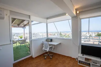 an office with a desk and a computer and windows at Glyfada Residence Top Floor With Sea & Tower View in Athens