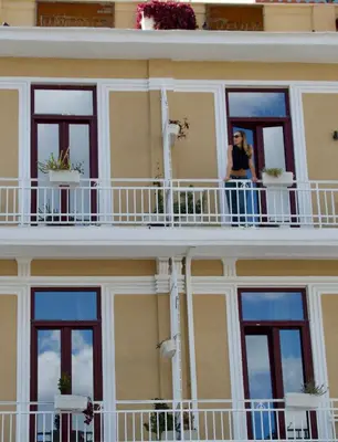 a woman standing on a balcony of a building at Mosaics Agora Boutique Hotel in Athens