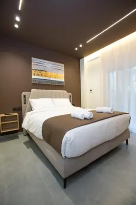 a bedroom with a large bed with two towels on it at Luxury apartments near athens city center in Athens