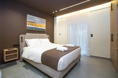 a bedroom with a large bed with two towels on it at Luxury apartments near athens city center in Athens