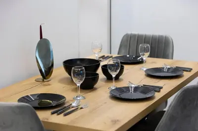 a wooden table with black plates and wine glasses at Piraeus Harbor Hideaway in Piraeus