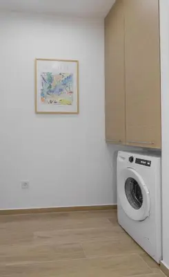 a washing machine in a room with a picture on the wall at Athenian Nest Studio by WeHost Athens in Athens