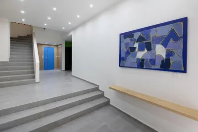 a hallway with stairs and a painting on the wall at Athenian Nest Studio by WeHost Athens in Athens