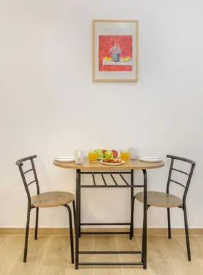 a table with two chairs and a plate of fruit on it at Athenian Nest Studio by WeHost Athens in Athens