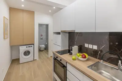a kitchen with a sink and a washing machine at Athenian Nest Studio by WeHost Athens in Athens