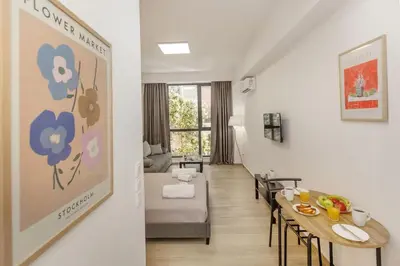 a living room with a table and a couch at Athenian Nest Studio by WeHost Athens in Athens