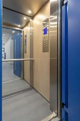 an elevator corridor with a glass door in a building at Athenian Nest Studio by WeHost Athens in Athens