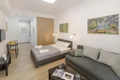 a living room with a bed and a couch at Athenian Nest Studio by WeHost Athens in Athens
