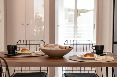 a wooden table with two plates and a bowl of food at Artemis House Athens in Athens