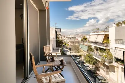 a balcony with two chairs and a view of a city at Artemis House Athens in Athens
