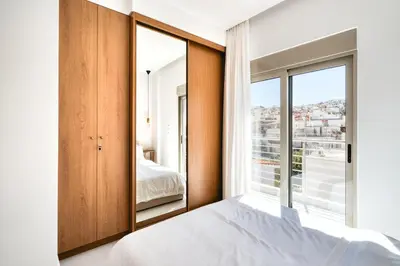 a bedroom with a bed and a large window at Artemis House Athens in Athens
