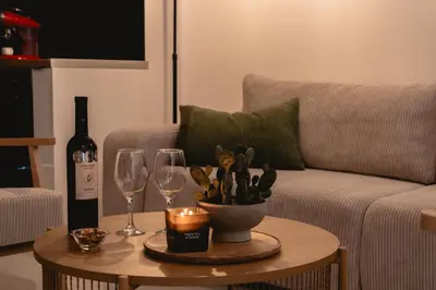 a living room with a couch and a table with wine glasses at Artemis House Athens in Athens