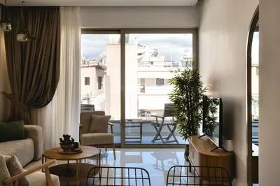 a living room with a view of a balcony at Artemis House Athens in Athens