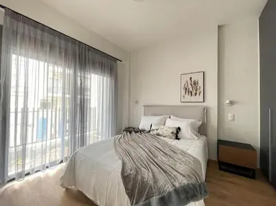 a bedroom with a large bed and a large window at Cityscape Brand New Flat in Athens
