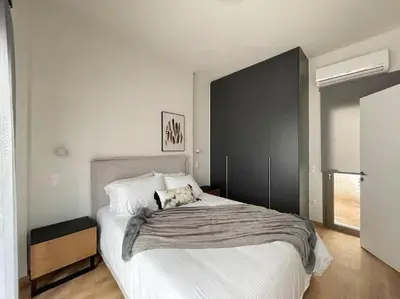 a bedroom with a large bed with a black wall at Cityscape Brand New Flat in Athens