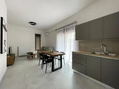 a kitchen with a table and a dining room at Cityscape Brand New Flat in Athens