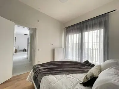 a bedroom with a large bed and a large window at Cityscape Brand New Flat in Athens