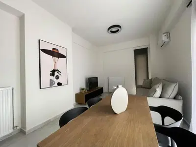 a living room with a wooden table and chairs at Cityscape Brand New Flat in Athens