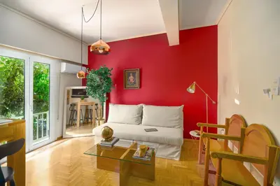 a living room with a red accent wall at Urban Νest in Athens next to Caravel in Athens