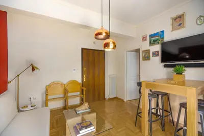 a living room with a table and a television at Urban Νest in Athens next to Caravel in Athens