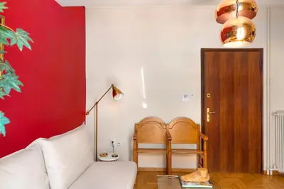a living room with a white couch and a red wall at Urban Νest in Athens next to Caravel in Athens