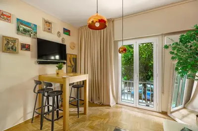 a living room with a table and chairs and a window at Urban Νest in Athens next to Caravel in Athens