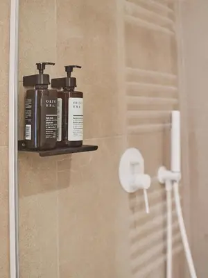 two bottles ofodorizers sit on a shelf in a bathroom at Real Athens K17 in Athens