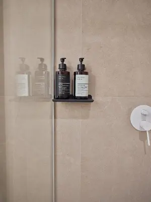 three bottles of soap sitting on a shelf in a bathroom at Real Athens K17 in Athens