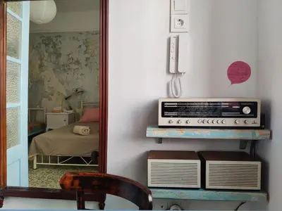a mirror reflecting a room with a radio on a shelf at Back to the 50's near metro by Traser in Athens