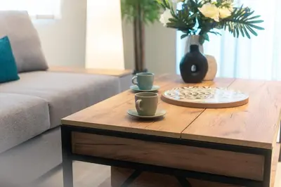 a coffee table with two cups and a vase with flowers at Spacious Modern 3BD Apartment in Athens