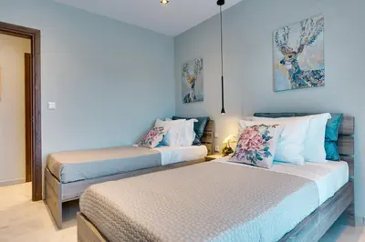two beds in a room with blue walls at Spacious Modern 3BD Apartment in Athens