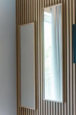 a mirror on a wall next to a window at Spacious Modern 3BD Apartment in Athens