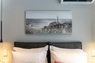 a bedroom with a bed with a painting on the wall at Spacious Modern 3BD Apartment in Athens