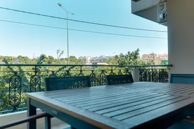 a table and chairs on a balcony with a view at Spacious Modern 3BD Apartment in Athens