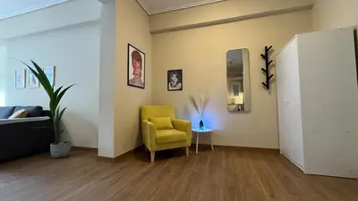a living room with a yellow chair and a mirror at Cozy apartment 10 min to acropolis in Athens