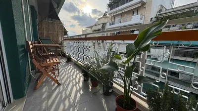 a balcony with plants and a chair on a building at Cozy apartment 10 min to acropolis in Athens