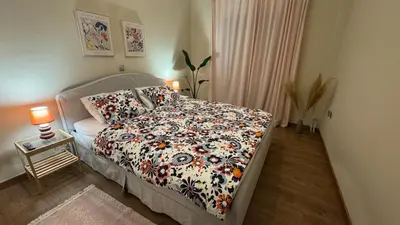 a bedroom with a bed with a floral comforter at Cozy apartment 10 min to acropolis in Athens