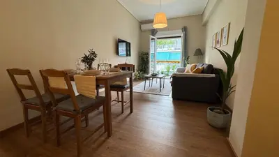 a living room with a table and chairs and a couch at Cozy apartment 10 min to acropolis in Athens