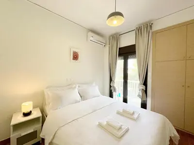 a bedroom with a white bed with two towels on it at Glifada Luxury Two-Bedroom Suite in Athens