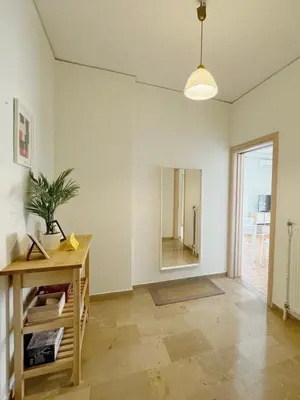 an empty living room with a table and a mirror at Glifada Luxury Two-Bedroom Suite in Athens