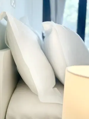 a pile of white pillows sitting on a couch at Glifada Luxury Two-Bedroom Suite in Athens