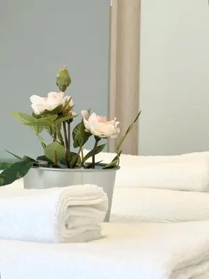 a vase with pink roses sitting on top of a bed at Glifada Luxury Two-Bedroom Suite in Athens
