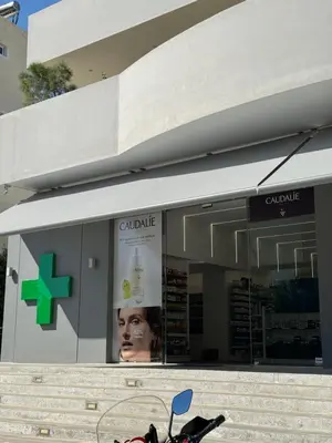 a store front with a green cross on the window at Glifada Luxury Two-Bedroom Suite in Athens