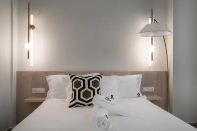 a bedroom with a bed with white sheets and pillows at ASPENGR Monastiraki Hotel & Apartments in Athens