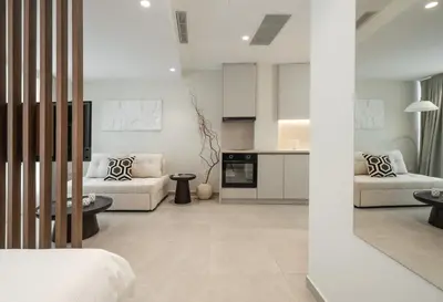 a living room with two white couches and a kitchen at ASPENGR Monastiraki Hotel & Apartments in Athens