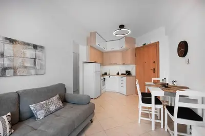 a living room with a couch and a table and a kitchen at Elysian Lycabettus - Horizon in Athens