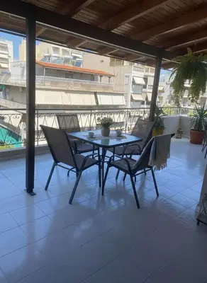 a table and chairs on a patio with a view at Aiolos - Faliro Haven in Athens